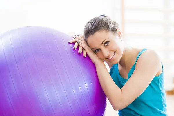 Jovem se exercitando com physioball no ginásio — Fotografia de Stock