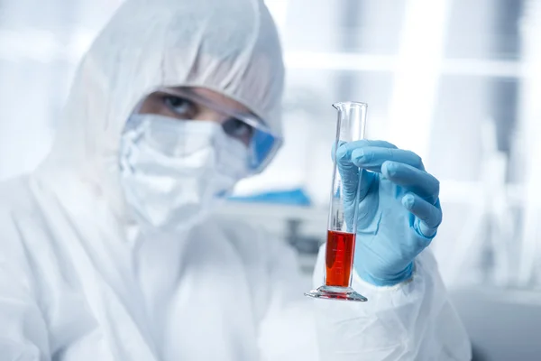 Researcher in hazmat suit with test tube — Stock Photo, Image