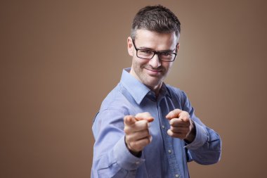 Cheerful businessman pointing at camera clipart