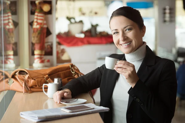 Leende kvinna dricker en kaffe — Stockfoto