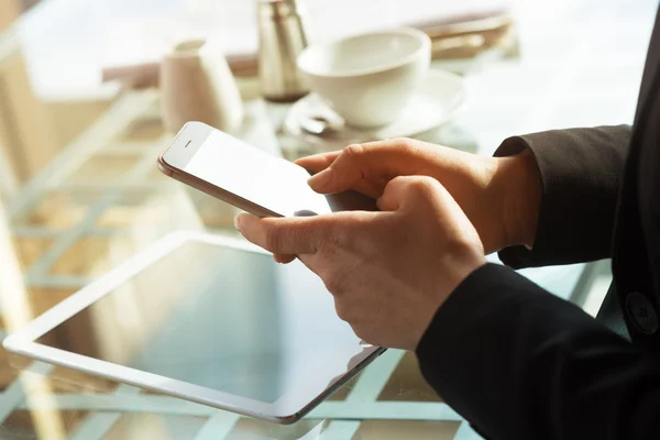 Geschäftsfrau, die während einer Kaffeepause mit ihrem Handy SMS schreibt — Stockfoto