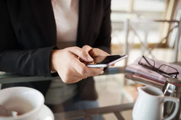 Geschäftsfrau, die während einer Kaffeepause mit ihrem Handy SMS schreibt — Stockfoto