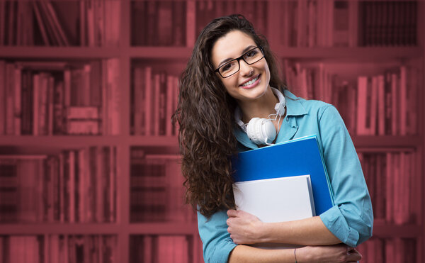 Красивая студентка позирует с блокнотами
