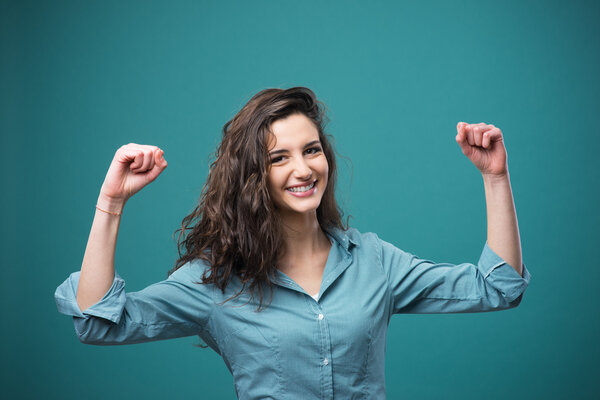Cheerful woman with raised fists