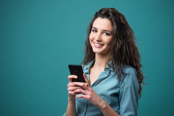 Усміхнена молода жінка з мобільним — стокове фото