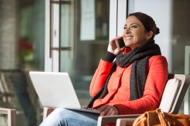 Kırmızı paltolu bir telefon olan çekici kadın