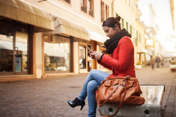 Šťastná žena sedící na lavičce — Stock fotografie