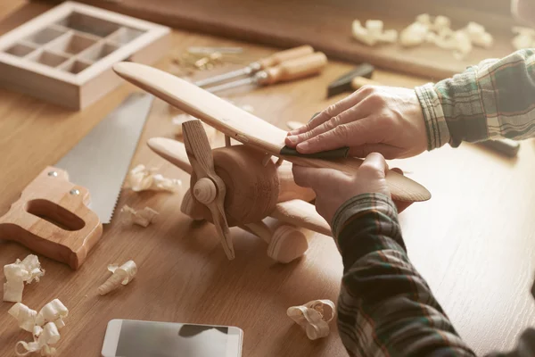 Craftsman building a wooden toy airplane — Stock Photo, Image