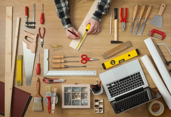 Hombre midiendo una tabla de madera — Foto de Stock