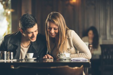 Arkadaşlar bir akıllı telefon kullanarak Café