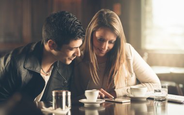 Arkadaşlar bir cep telefonu kullanarak Café