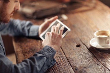 Genç adam bir değmek perde tablet kullanarak