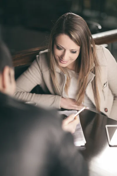 Modieuze paar aan de bar met behulp van een slimme telefoon — Stockfoto