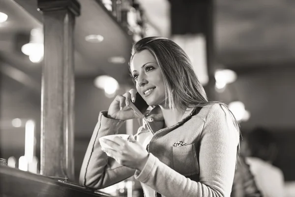 Mulher sorridente no bar a fazer um telefonema — Fotografia de Stock