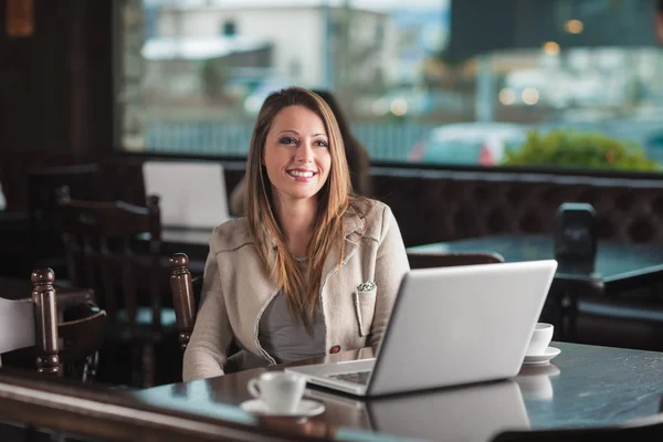 Hermosa mujer en el café con un ordenador portátil — Foto de Stock