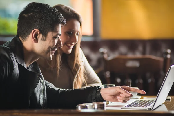 Pareja en el bar usando un portátil — Foto de Stock