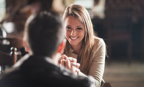Romantic couple holding hands at the bar
