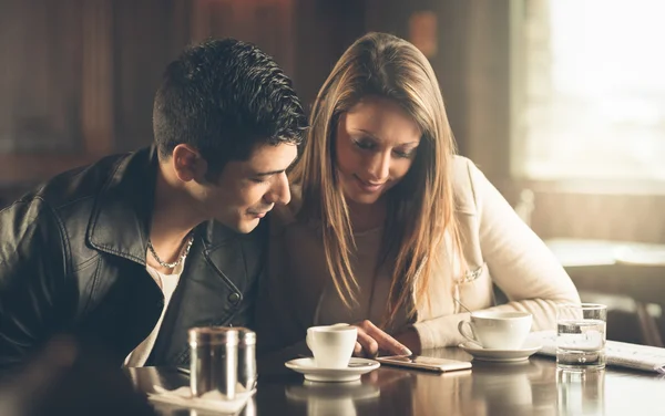 Friends at the cafe using a mobile phone — Stock Photo, Image