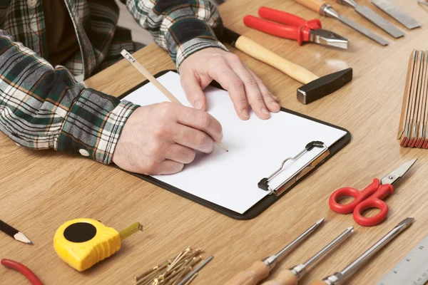 Homem esboçando um projeto DIY no papel — Fotografia de Stock