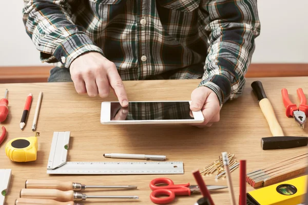 Artesano trabajando en un proyecto de bricolaje con su tableta — Foto de Stock