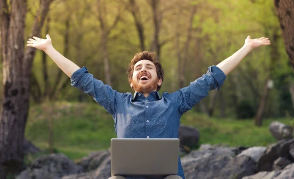 Hipster feliz com laptop na floresta — Fotografia de Stock