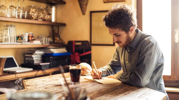 Junger Hipster skizziert in seinem Atelier — Stockfoto