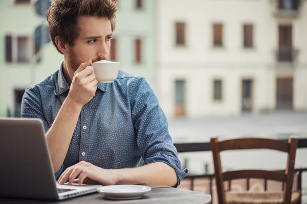 Jeune homme au bar avec un ordinateur portable — Photo