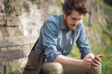 Bir yürüyüş, onun cep telefonu ile mesaj sahip hipster adam