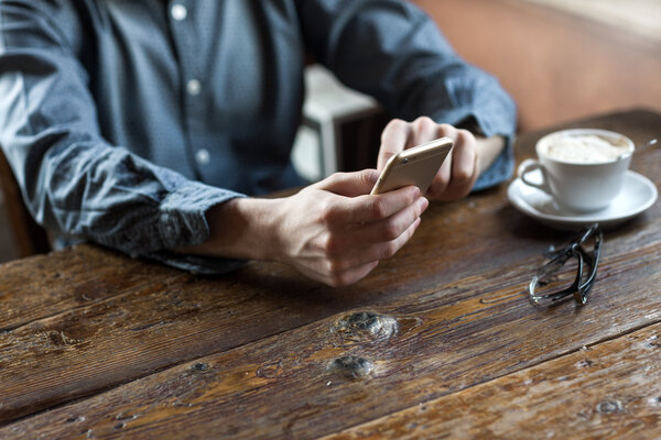 Молодой человек использует мобильный телефон в баре
