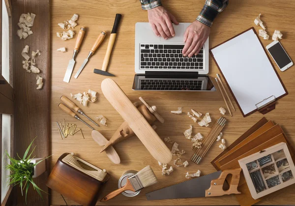 Hombre trabajando en un proyecto de bricolaje con su laptop — Foto de Stock