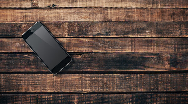 Black mobile phone on a wooden table