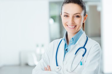 Confident female doctor posing in her office