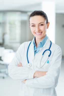 Confident female doctor posing in her office
