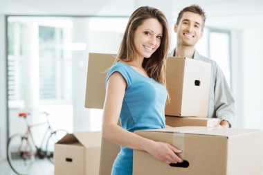 Smiling couple moving in a new house clipart