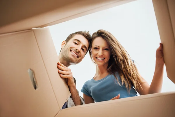 Pareja feliz abriendo una caja Imagen de stock