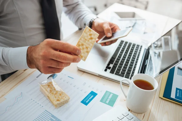 Geschäftsmann isst einen Imbiss — Stockfoto