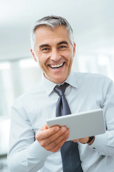 Leende affärsman med hjälp av en digital tablet — Stockfoto