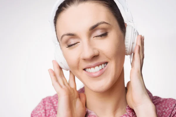 Улыбающаяся женщина слушает музыку — стоковое фото