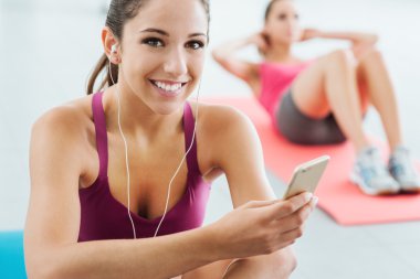 Genç kadın spor salonunda müzik dinlemek