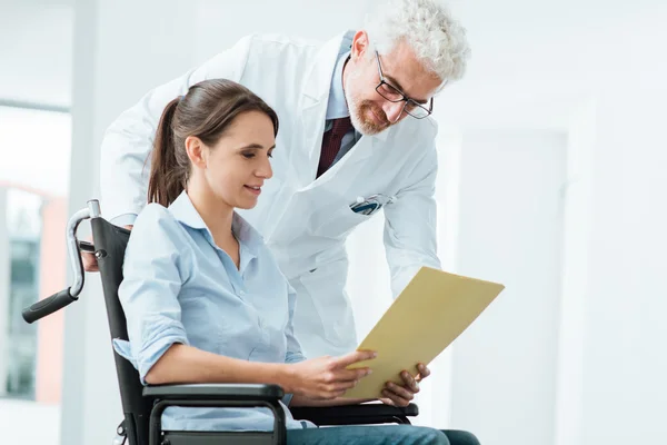 Médico y paciente examinando historias clínicas —  Fotos de Stock