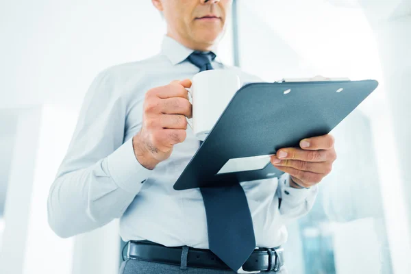 Executivo trabalhando durante sua pausa para o café — Fotografia de Stock