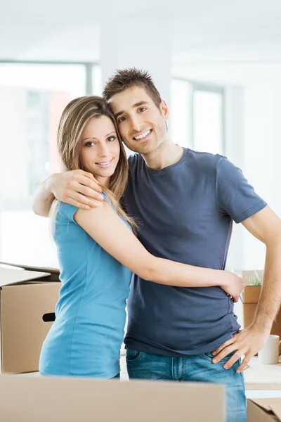 Jong koppel knuffelen in hun nieuwe huis — Stockfoto