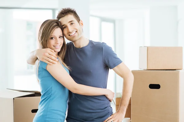 Jovem casal abraçando em sua nova casa — Fotografia de Stock