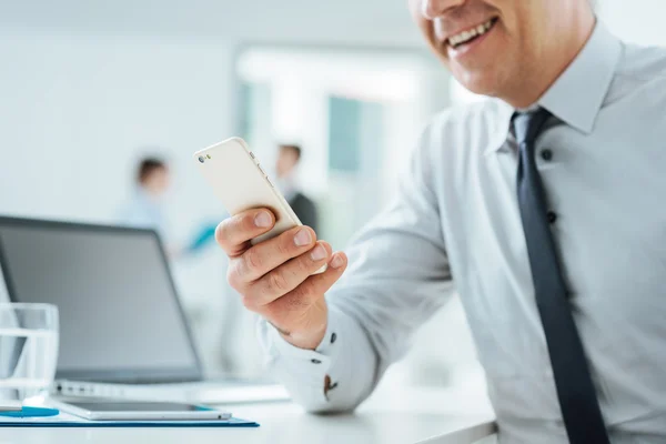 Homme d'affaires au bureau utilisant un téléphone intelligent — Photo