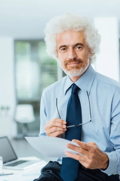 Uomo d'affari fiducioso che legge documenti — Foto Stock