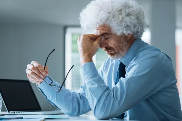 Stressad affärsman sitter vid office skrivbord — Stockfoto
