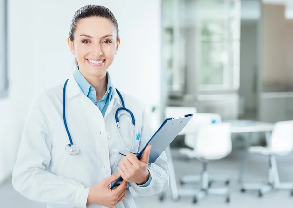 Usmívající se žena doktor drží lékařských záznamů — Stock fotografie