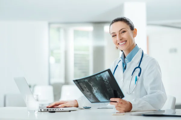 Lächelnde Ärztin bei der Untersuchung eines Röntgenbildes — Stockfoto