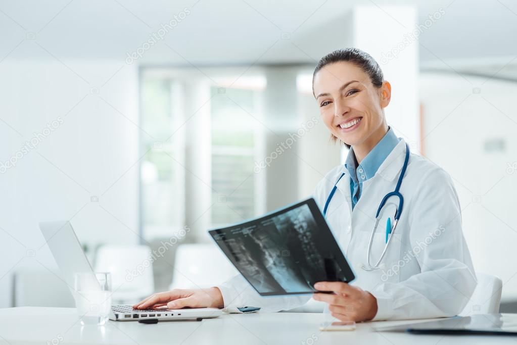 Smiling female doctor examining an x-ray