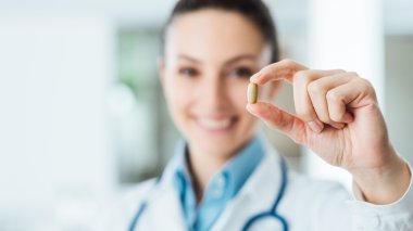 Eczacı elinde hap tutuyor.